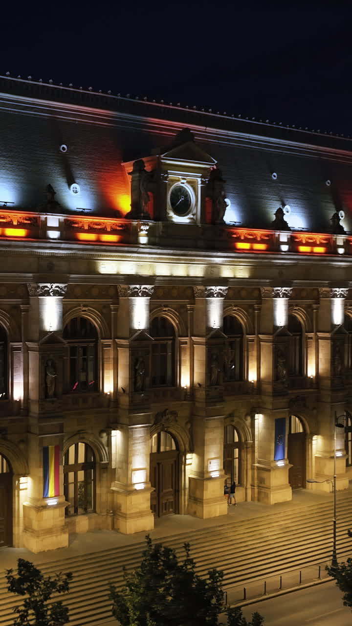 Aerial drone view of the illuminated Palace of Justice in Bucharest, Romania, at night. Vertical