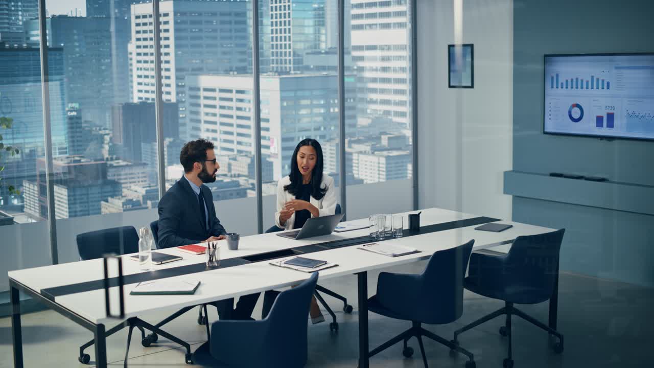 Businesspeople in Modern Office: Businesswoman and Businessman Use Laptop Computer, Talk. Top Manager and Partner Investor Discuss e-Commerce Software Global Investment Strategy. Elevating Wide Shot