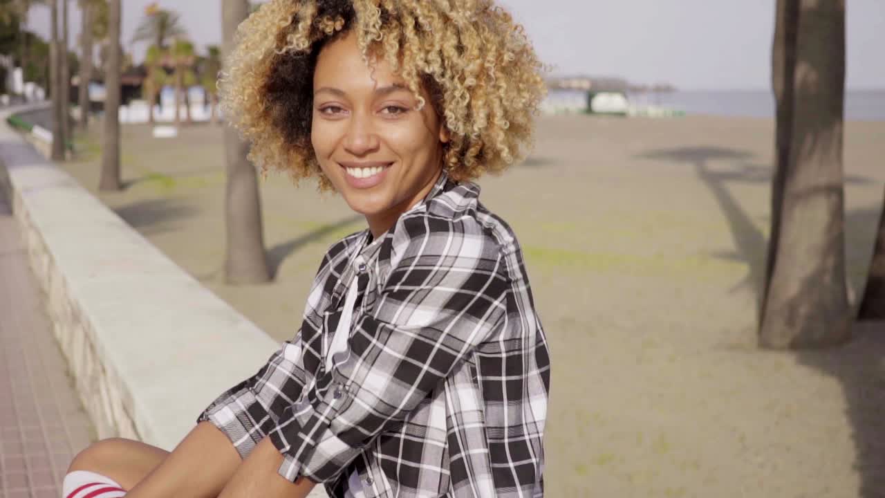 Giovane donna felice e alla moda con uno skateboard