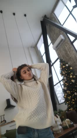 mujer con un suéter blanco en un interior acogedor de navidad