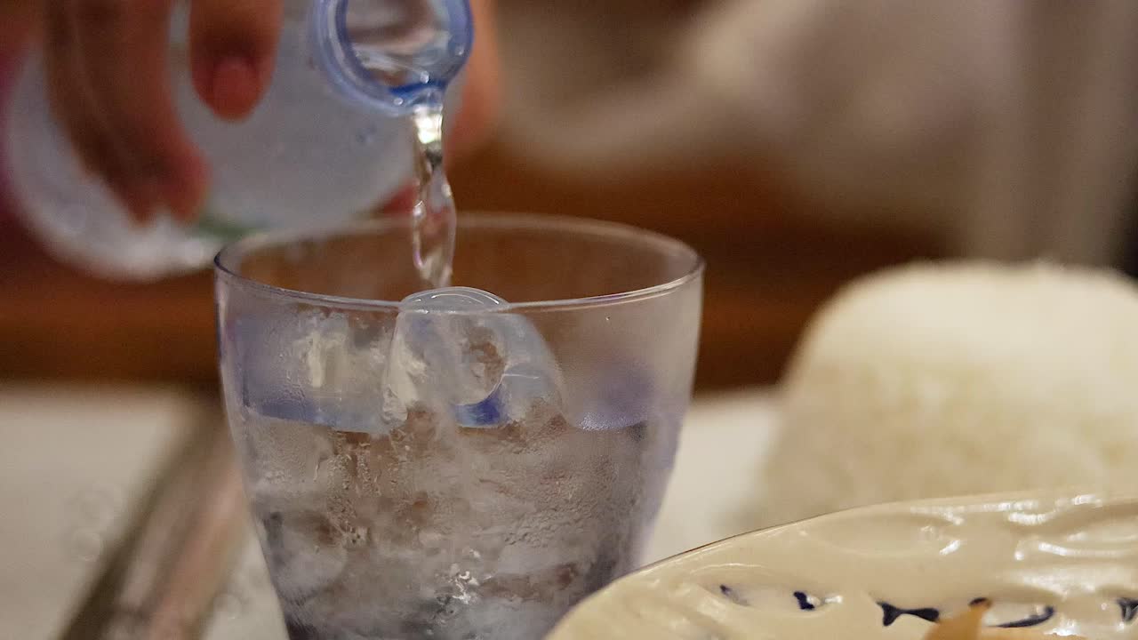 얼음 이 있는 유리잔 에 물 을 부어 넣는 것