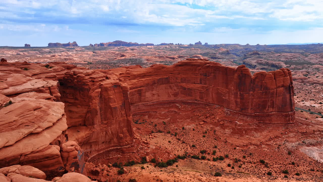 Avvicinamento alla parete di roccia rosso brillante con sommità piatta. Filmato aereo nel Parco nazionale degli Arches nello Utah, USA