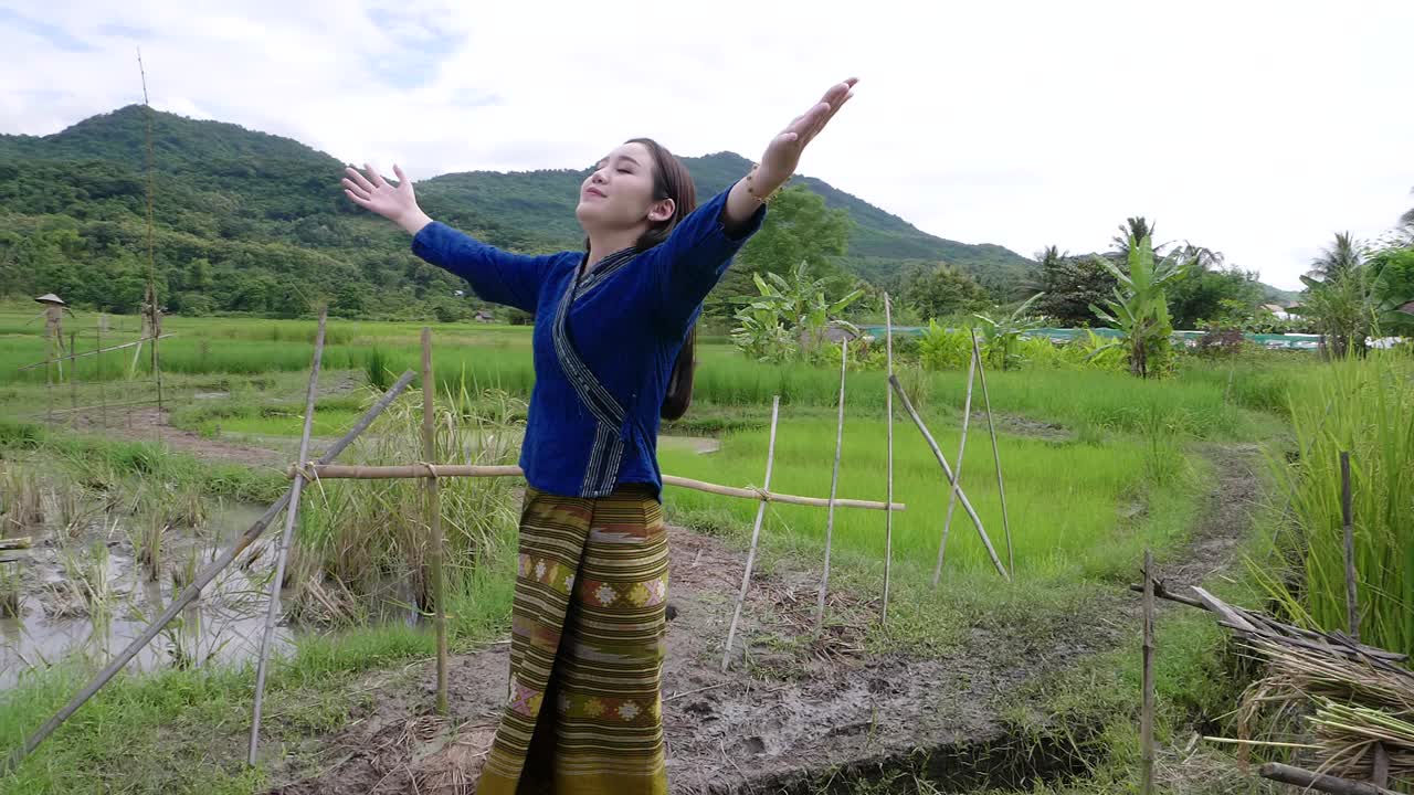 Woman in Traditional Clothing in a Rice Paddy