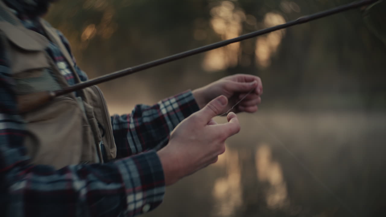 Fisherman Tying Fly Fishing Line at Sunrise