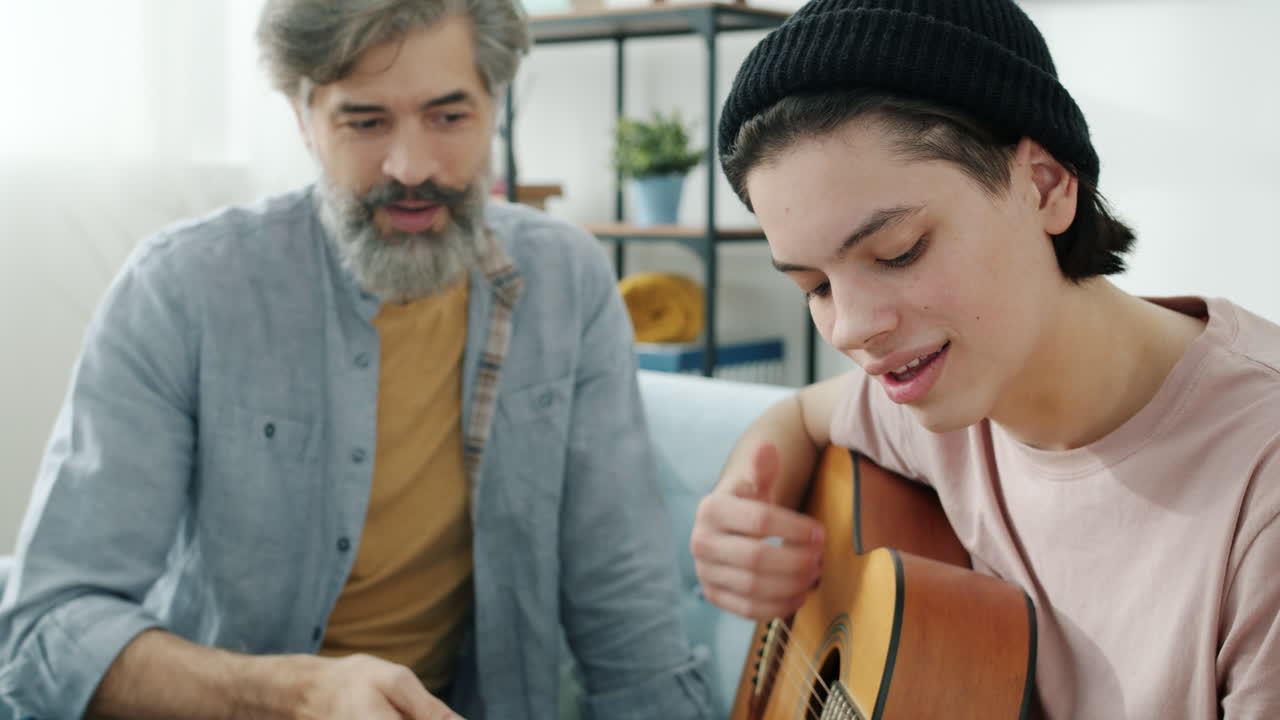 Father teaching his son to play guitar