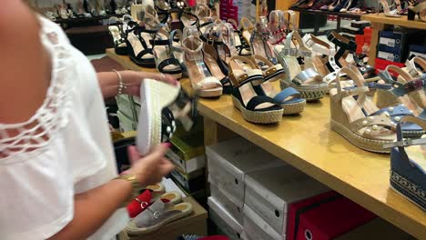 Girl-with-white-top-and-bare-shoulders-shopping-for-summer-shoes