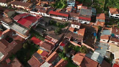 enjoy a stunning descending aerial shot towards san blas lookout, showcasing the tejas roofs and green courtyards in cusco