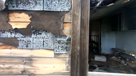 the outside of a wooden old abandoned house in the country looking into the window.