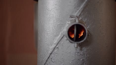 fuego en una pequeña estufa de leña de acero plateado de cerca