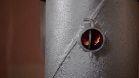 fire in a small silver steel wood burning stove close up