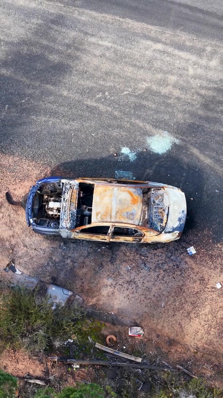 Vista aerea di un relitto di auto bruciata sul ciglio della strada