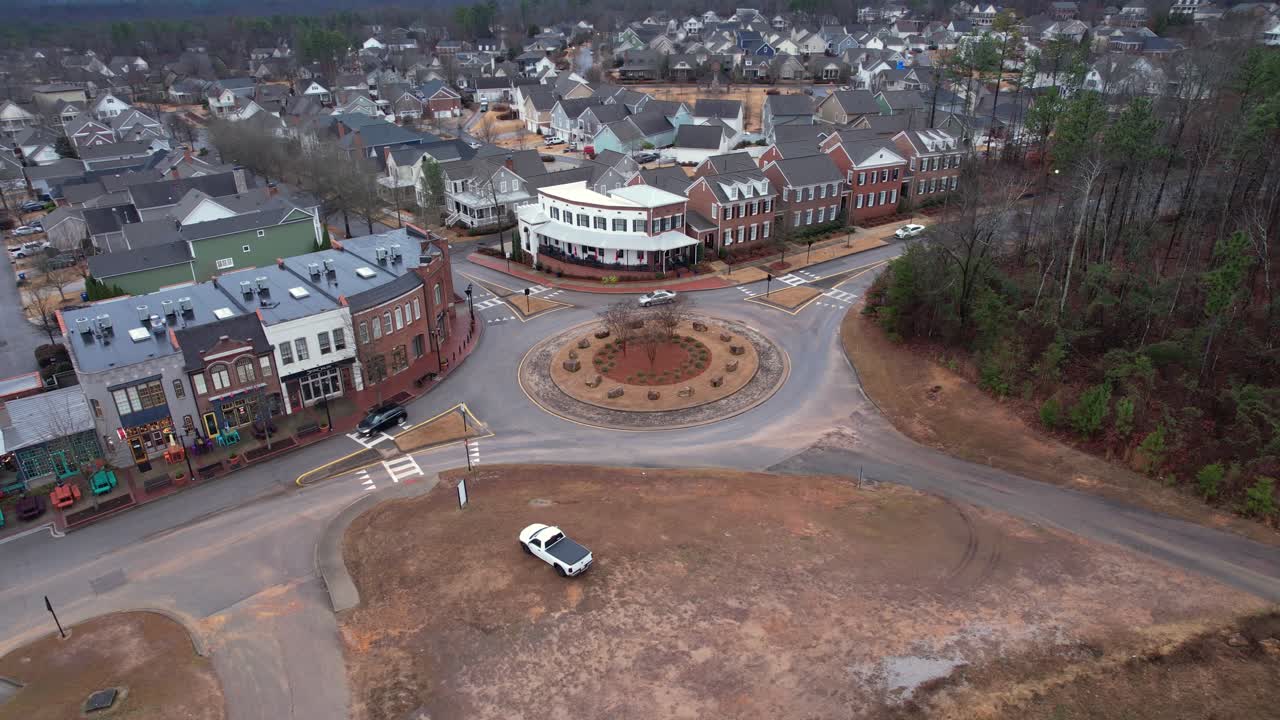Aerial pan of small town shops and roundabout in front of suburban area at Moss Rock Preserve in Hoover, Alabama