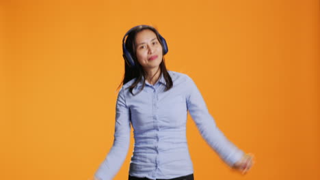 funky woman listening to songs on headset gadget and dancing