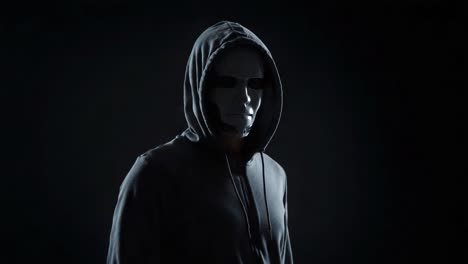 a captivating exploration of an enigmatic figure shrouded in mystery, featuring a hooded character with a mask that prompts questions about identity and technology