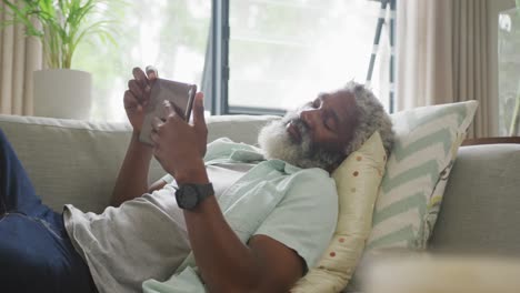 Video-Eines-Traurigen-Afroamerikanischen-älteren-Mannes,-Der-Auf-Dem-Sofa-Liegt