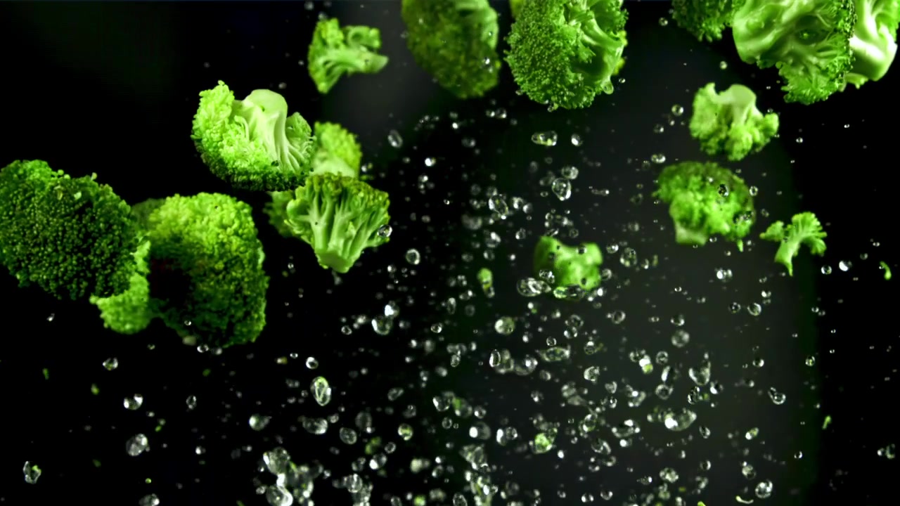 Cimette di broccoli verdi freschi che schizzano con l'acqua al rallentatore