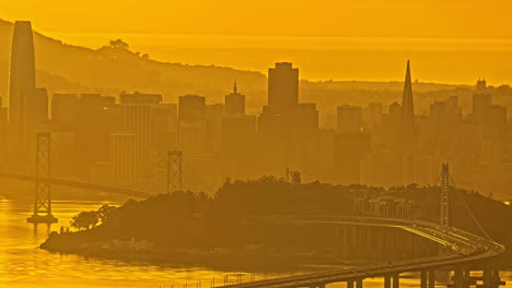 time lapse, san francisco cityscape skyline, oakland bridge traffic and yellow mist above city and bay