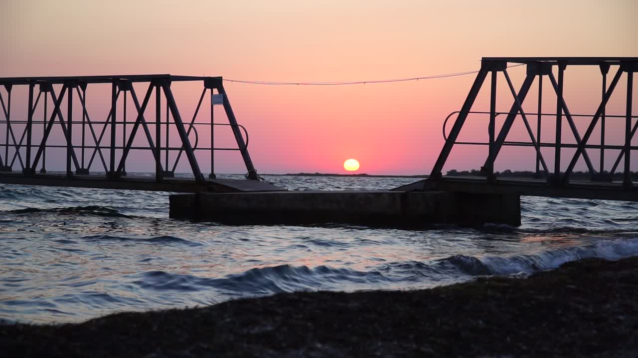 바다에 분홍색 일출의 다리