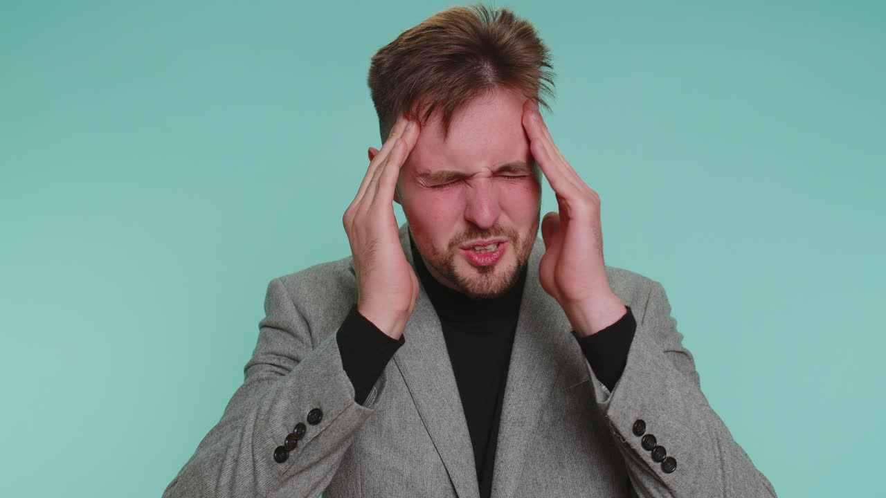 Business man rubbing temples to cure headache problem suffering from tension and migaine stress pain