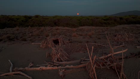 tipi de madera junto al mar en una playa natural durante el atardecer
