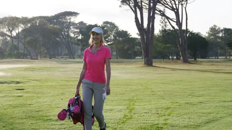 female golfer walking with golf bag