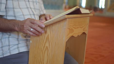 man reading quran in mosque