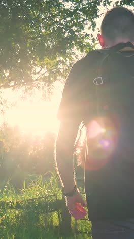 man walking in a field at sunset