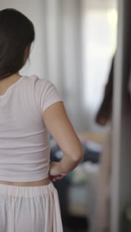 mujer preparándose frente a un espejo