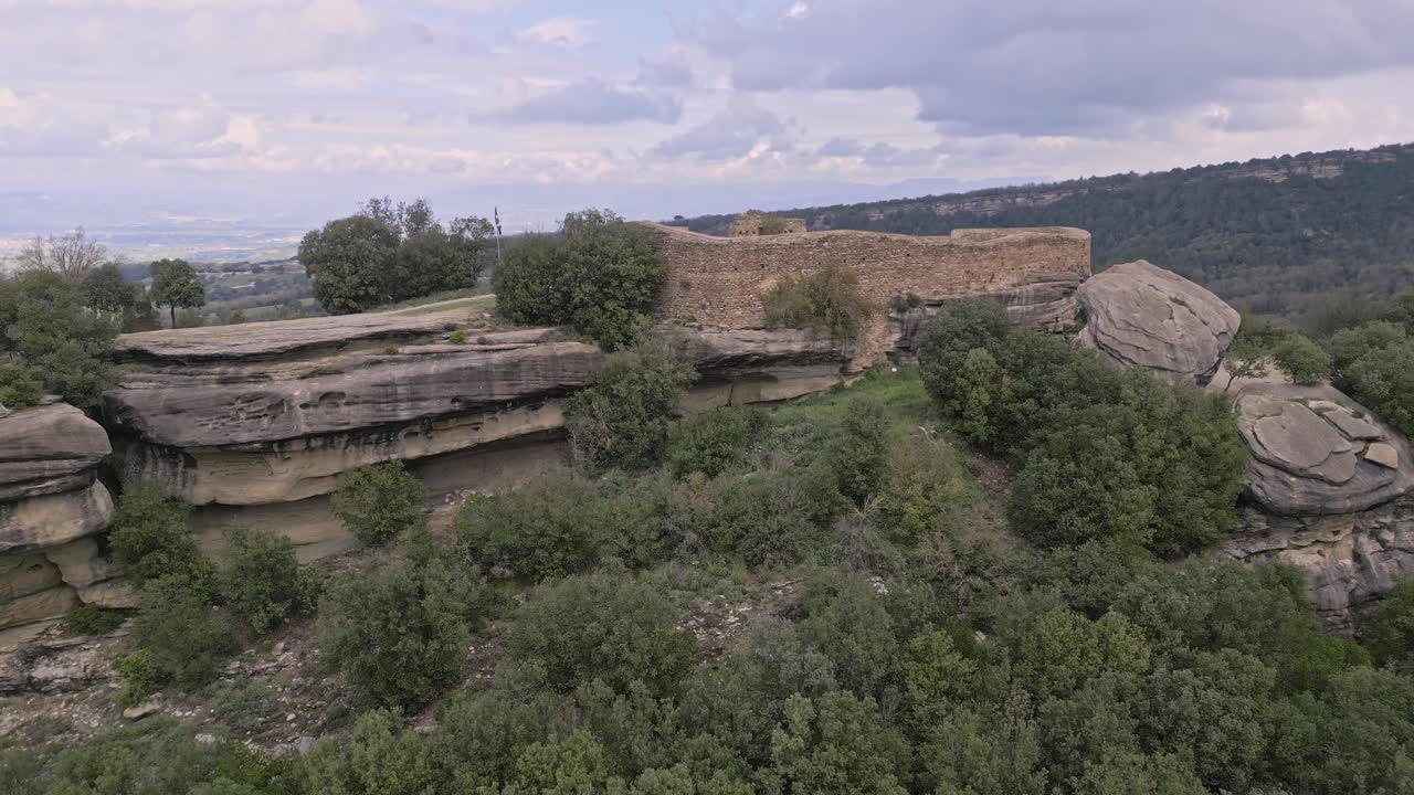 Panning view of the eighth century castle of taradell, built on a rocky promontory and surrounded by lush vegetation, in barcelona, catalonia, spain