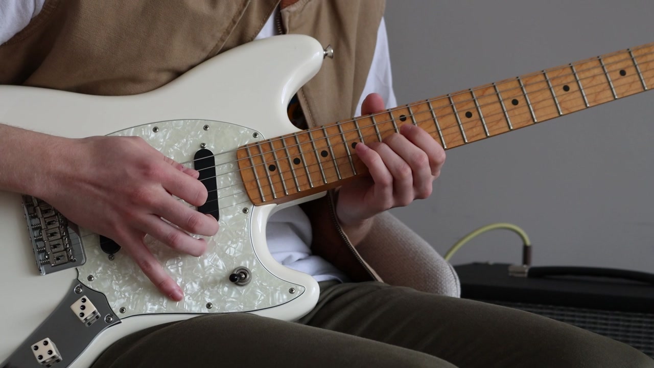 The guitar player bends the strings of the electric guitar using the bending technique