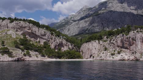 Versteckter-Strand-In-Der-Nähe-Von-Makarska,-Umgeben-Von-Felsigen-Klippen-Und-Klarem-Blauen-Wasser-An-Einem-Sonnigen-Tag