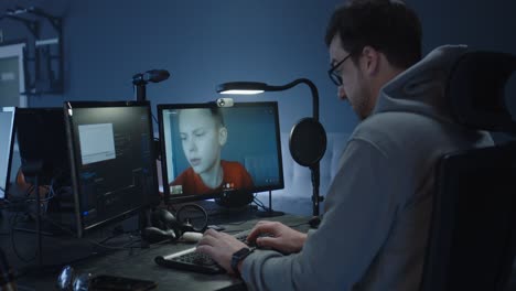 man having a video call with a teenager while coding