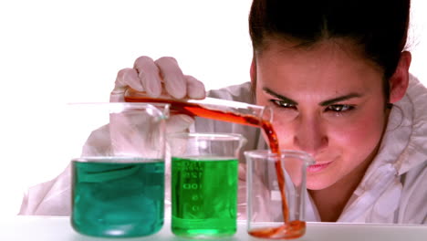 científico vertiendo líquido rojo en un vaso