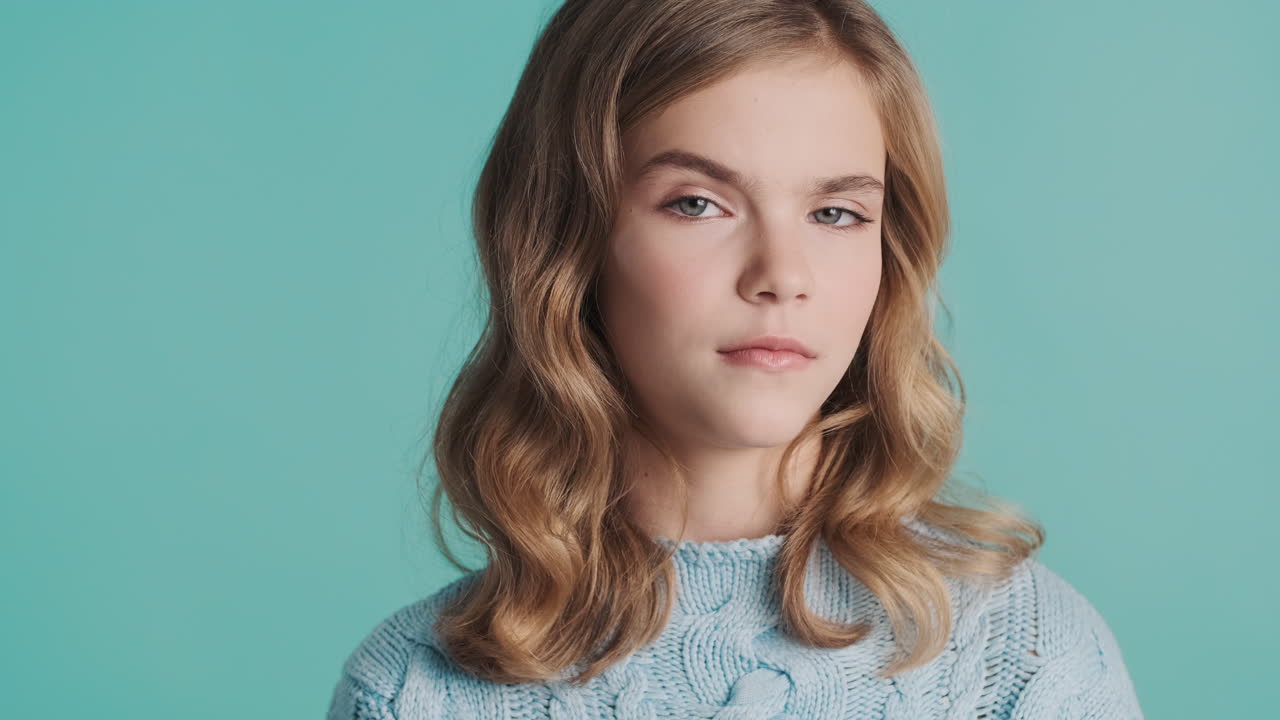 Teenage Caucasian girl raising eyebrow at the camera.