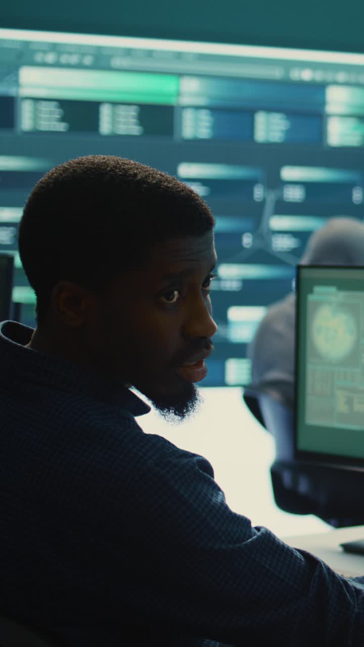 Young Man Working on Computer in Dark High-Tech Control Room