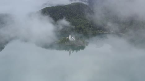 misty lake bled island with church reflection