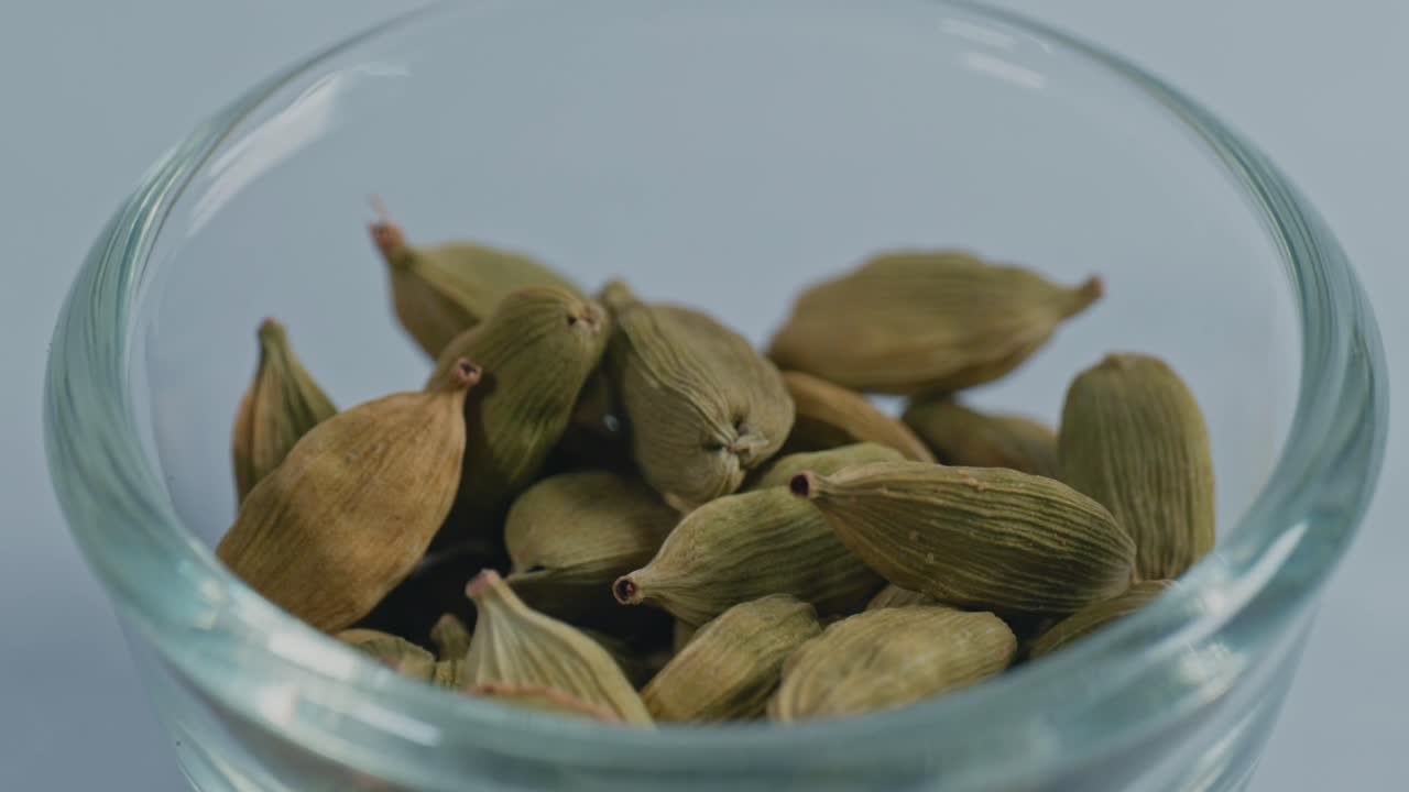 green elaichi or green cardamom in small glass bowl, 4k, parallax shot.