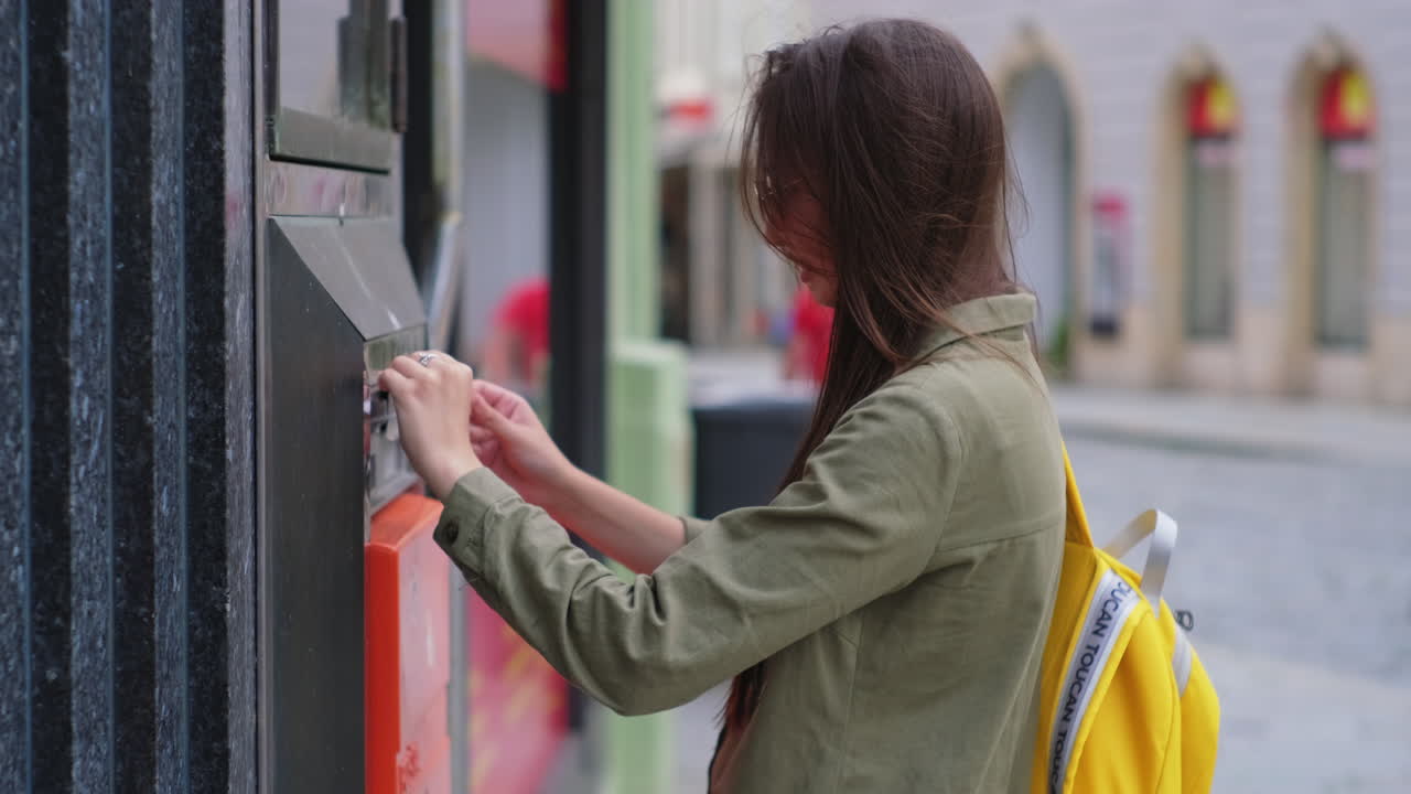 mujer usando la máquina de pago de estacionamiento