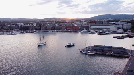 aerial oslo sunset harbor scene, big sailing vessel looking to dock