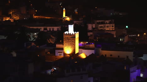 illuminated minaret tower of a mosque with lighted firework in the town of chefchaouen, morocco