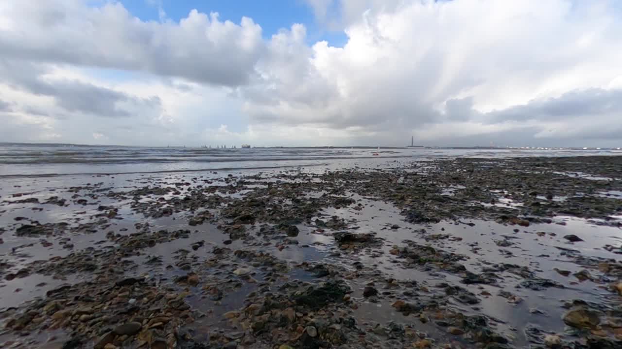 Time-lapse di una spiaggia di ciottoli nel Regno Unito con nuvole che sfrecciano in alto