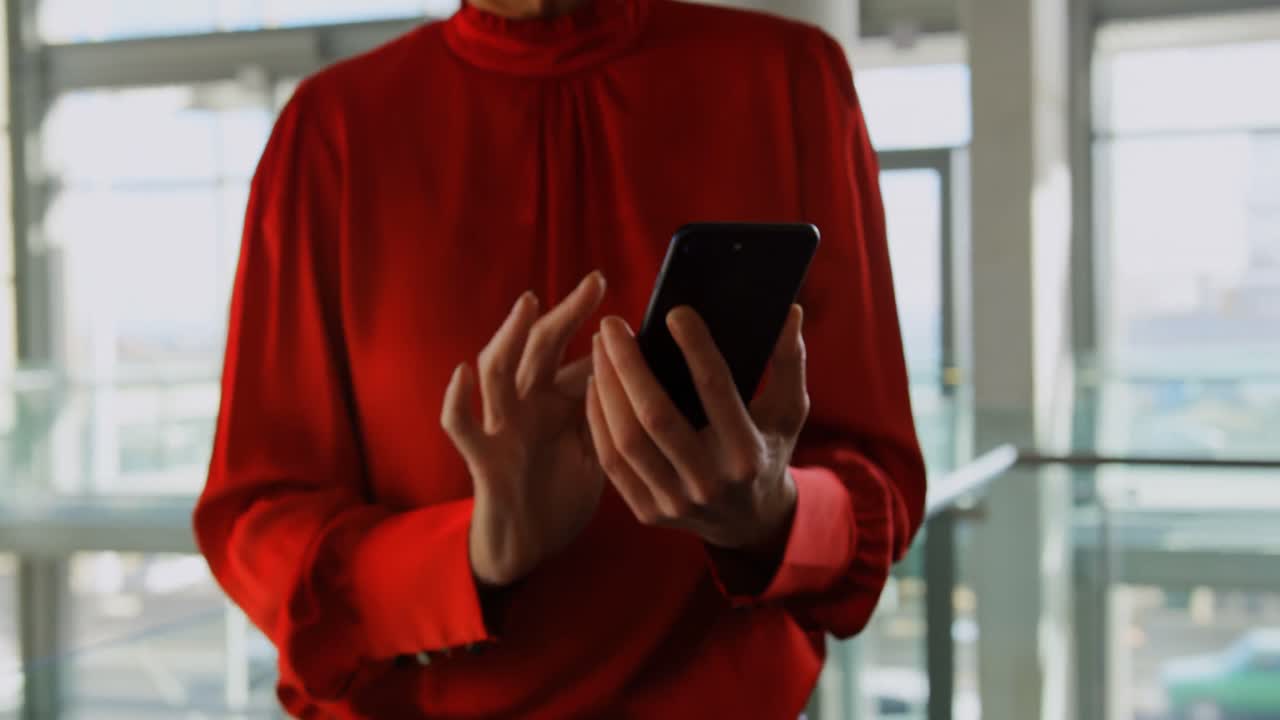 mujer de negocios usando el teléfono móvil en la oficina 4k