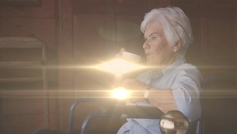 animación de la luz moviéndose sobre una mujer caucásica mayor en silla de ruedas bebiendo café