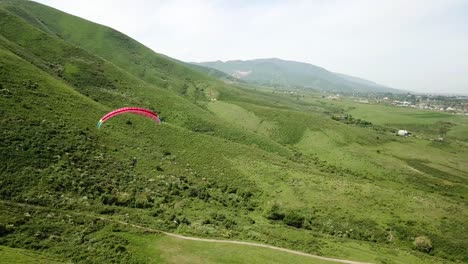 paragliding in the mountains. green fields, hills