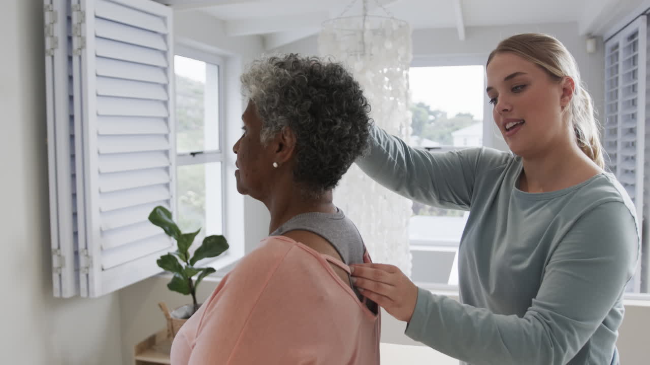 Caucasian female physiotherapist checking neck of senior woman, copy space, slow motion