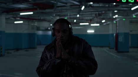 scary black man in dark underground parking lot, planning something bad