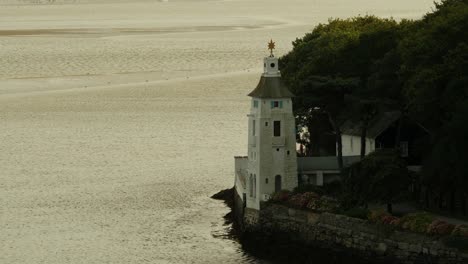 lighthouse on the coast of portmeirion at sunset, river dwyryd, north wales, uk