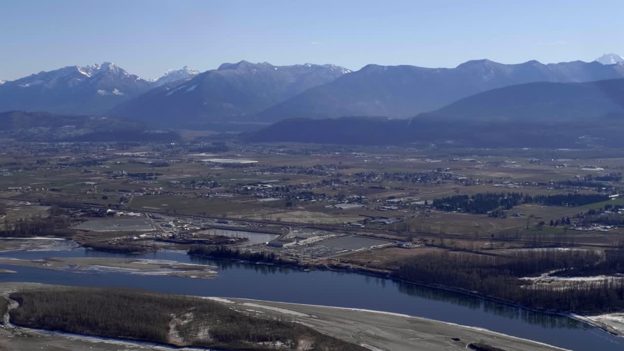 A Scenic View of Chilliwack, Surrounded by Farmland, the Fraser River, and the Cascade Mountains in British Columbia, Canada - Aerial Drone Shot