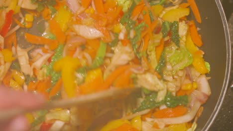 pov point of view of steam rising from hot stir fry healthy vegetables being cooked in wok pan causing haze on camera lens 4k