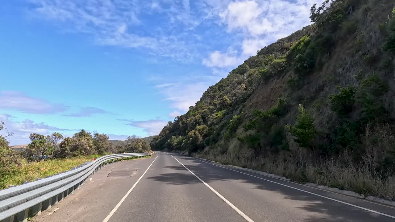 A 30-second video capturing a drive along the Great Ocean Road, showcasing coastal views and lush greenery under clear skies